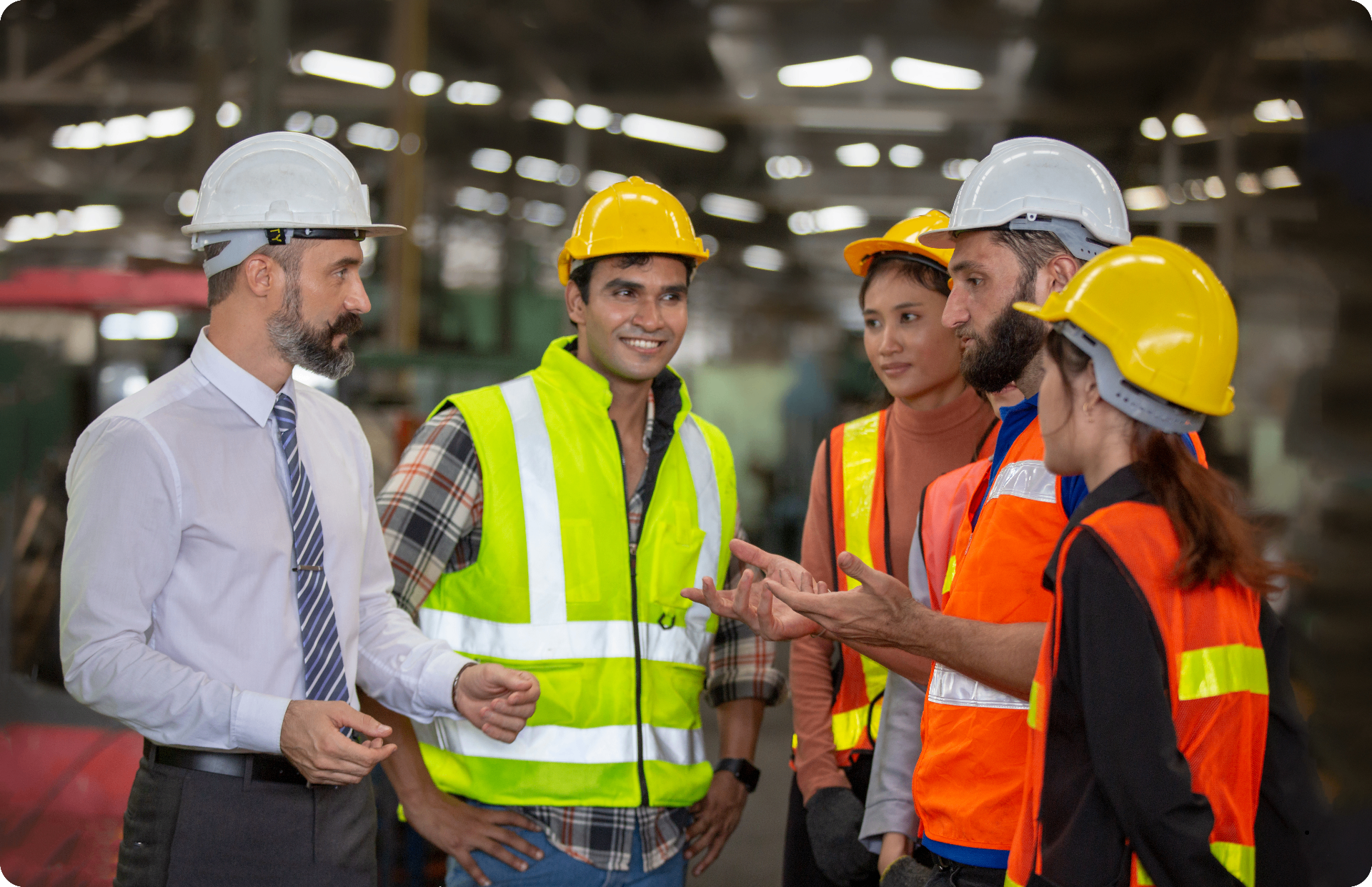 Diverse manufacturing workers collaborating with their New Heights Languages instructor