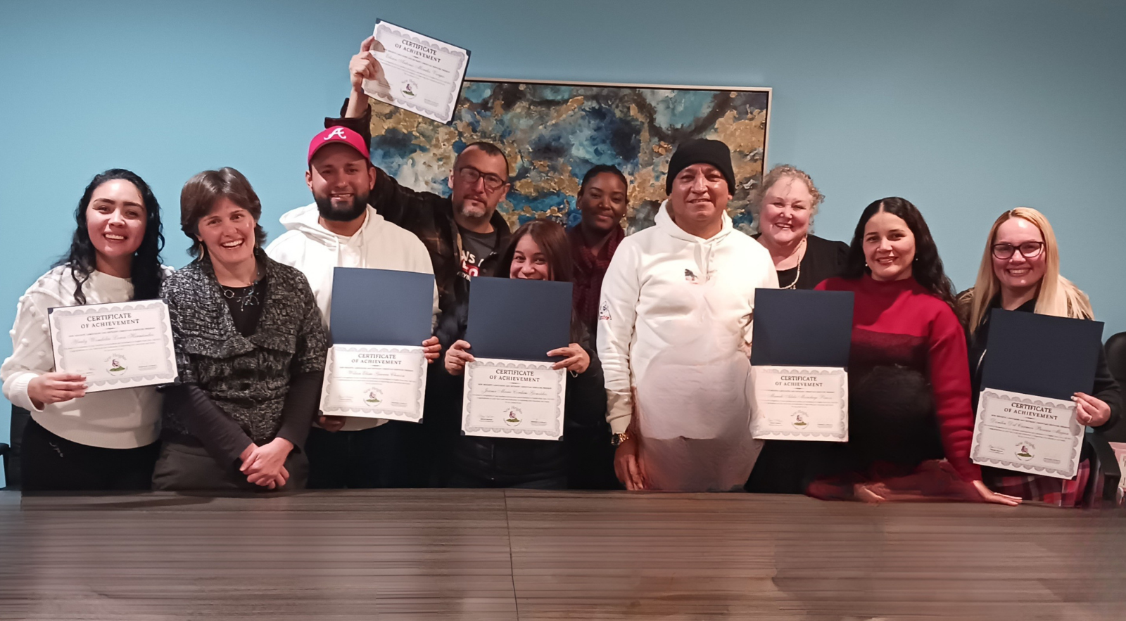 A large group of New Heights Languages employees celebrating with certificates of achievement
