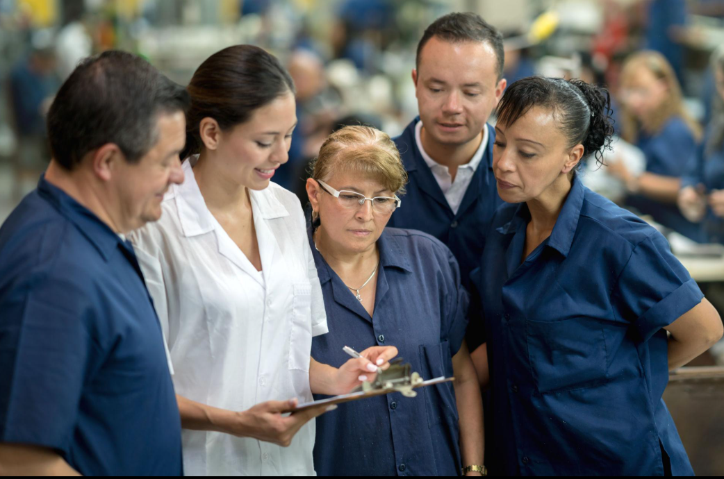 Equipo de trabajadores de manufactura de diversas nacionalidades colaborando